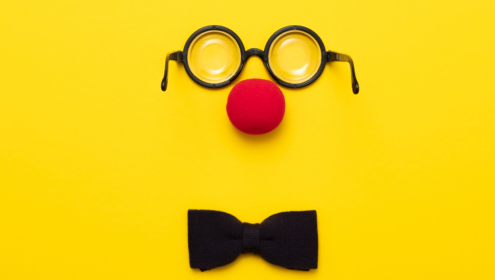 An image of a clown nose, glasses and bow tie for an article about clowning for actors.
